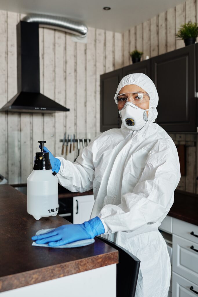 Bilden visar en person som rengör ett kök. Mögelsaneringsvätska är en luktsaneringsvätska inom kategorin för saneringsvätskor och finns även som miljövänligare kemprodukter.