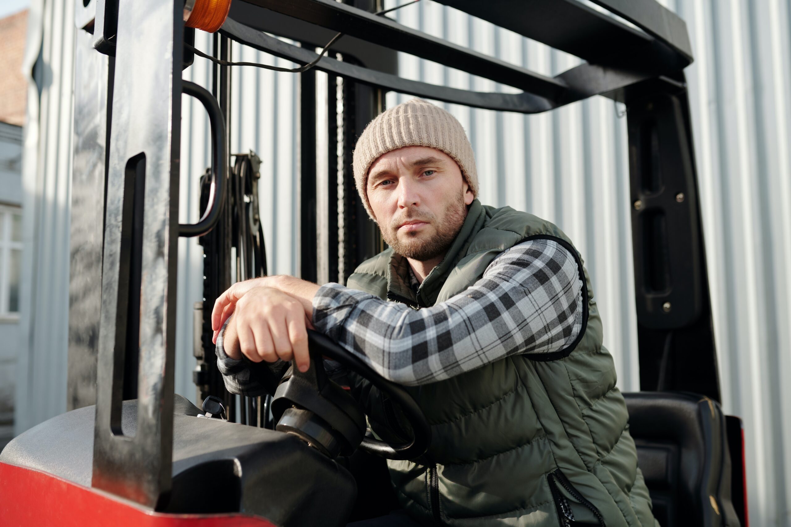 Bilden visar en person som sitter i en ledstaplare som är en typ av truck eller gaffeltruck.