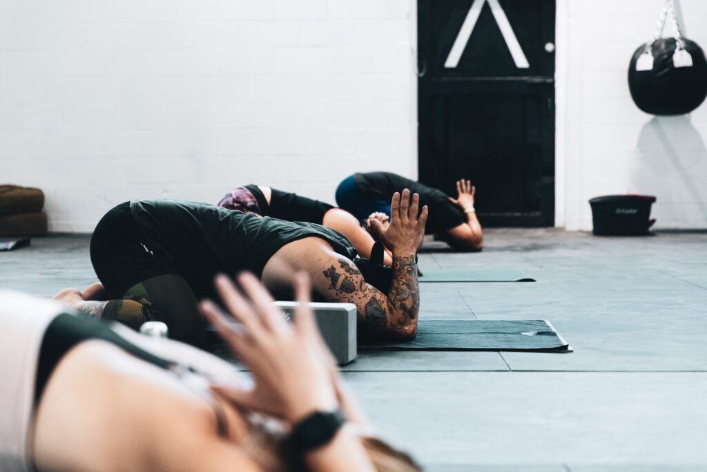 Bilden visar personer som utöver yoga. Yoga block är praktiska tillbehör för att underlätta vid olika asanas.